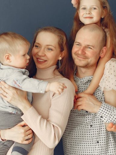 A joyful family portrait showcasing parents and their two children, expressing love and togetherness.