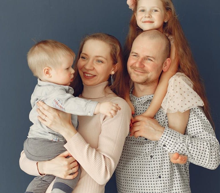 A joyful family portrait showcasing parents and their two children, expressing love and togetherness.